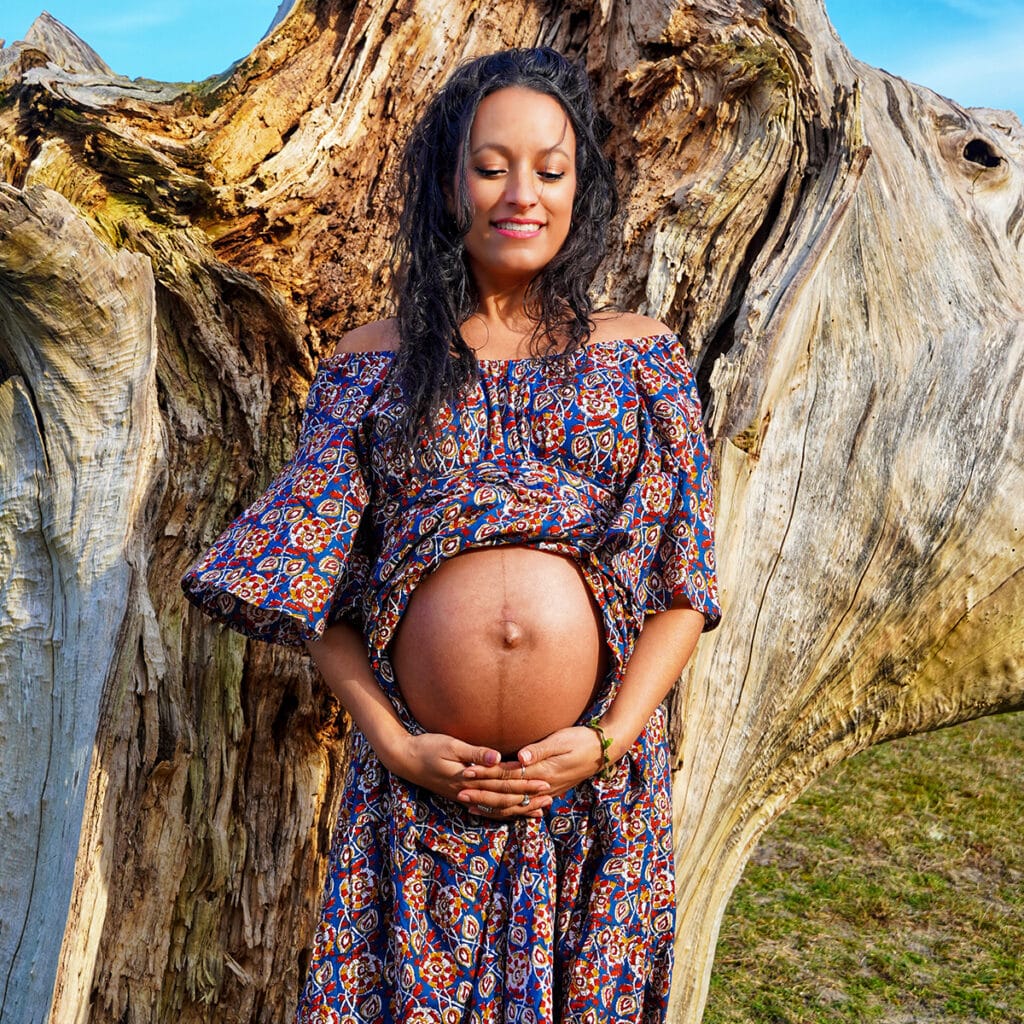 Vriendinnen zegenen de zwangere buik met bloemen tijdens de ceremonie